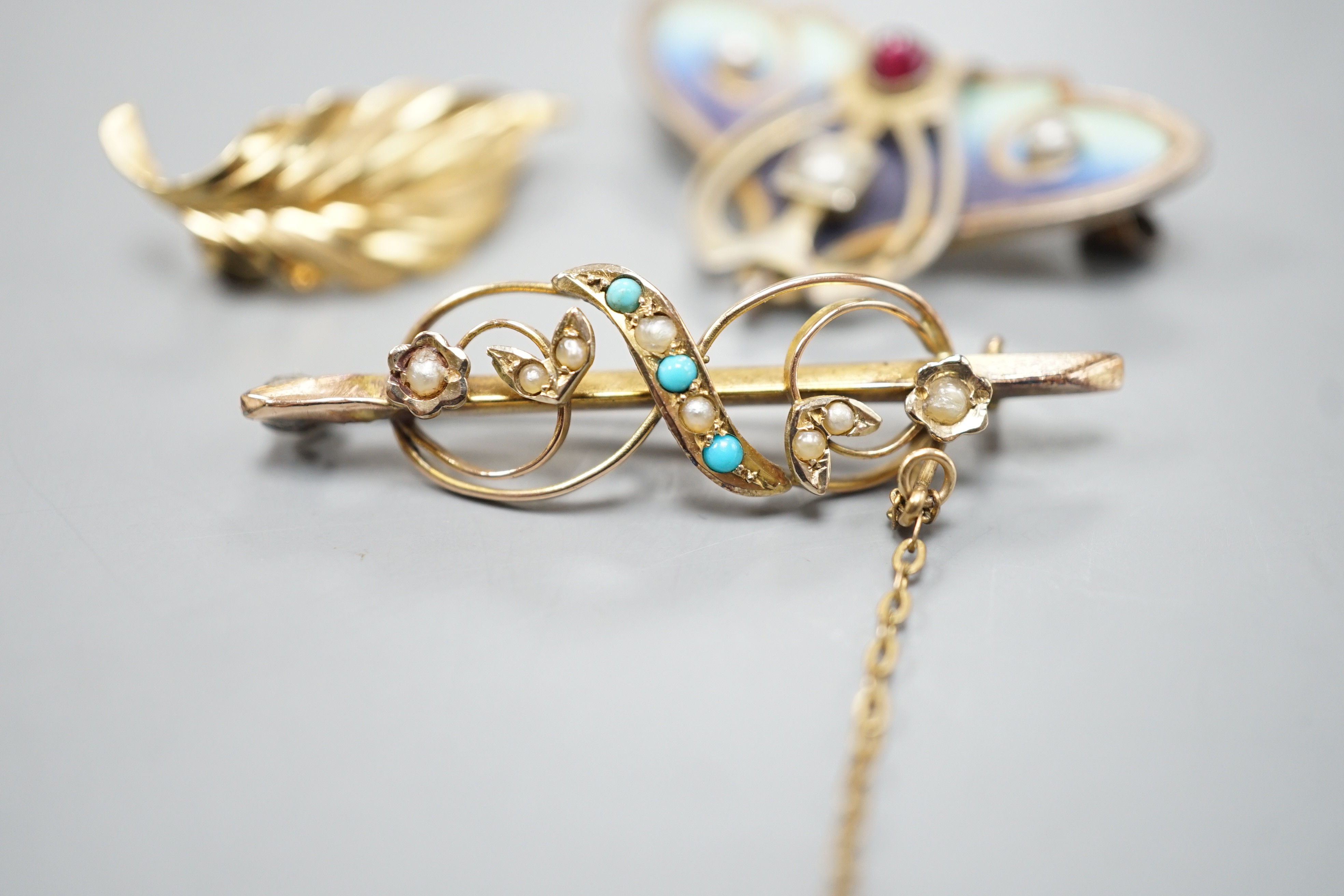 A continental Art Nouveau 900 gilt white metal, cabochon stone, seed pearl and enamel set brooch, 36mm and two 9ct brooches including gem set, 9ct gross 4.2 grams.